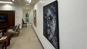 Un pasillo con una decoración moderna, que incluye una televisión de pantalla plana, un área de descanso y obras de arte en las paredes.
