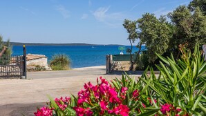 Une route côtière avec une barrière, un panneau indicateur et une vue sur la mer.