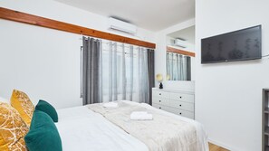 A bedroom with a bed, a dresser, a TV, and a window with curtains. - Villa AD Astra by Villas Guide (Sesvete)