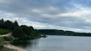 A calm lake surrounded by dense forest and a dirt path. - Cottage by River with Spa near Carcassonne (Caudebronde)