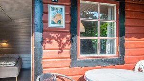 A room with a bed, a chair, a table, and a window with a picture frame. - 2 Person Holiday Park Home in Aabenraa (Aabenraa)