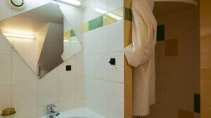 Une salle de bain équipée d’un lavabo, d’un miroir et d’un porte-serviettes.