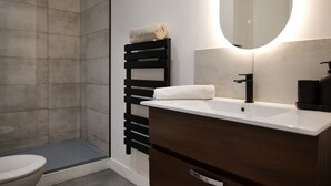 A modern bathroom with a shower, toilet, and vanity with a mirror. - Apartment for 2, Ideal Location in Downtown Angers (Angers)