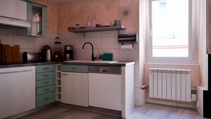 Una cocina con lavavajillas, estufa y ventana.