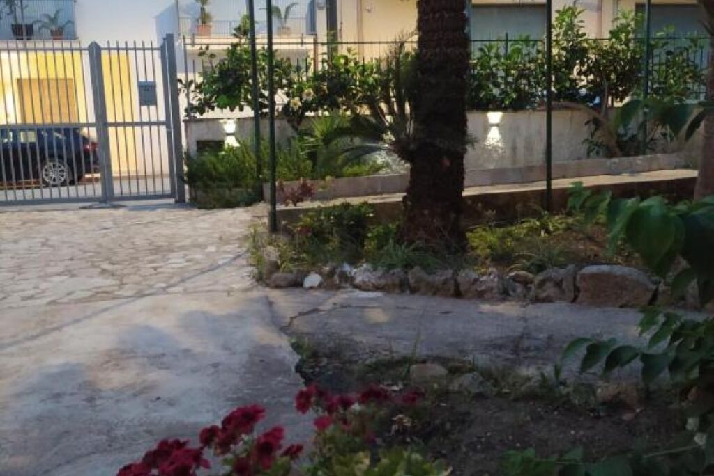 A gated entrance with a paved driveway leading to a building.