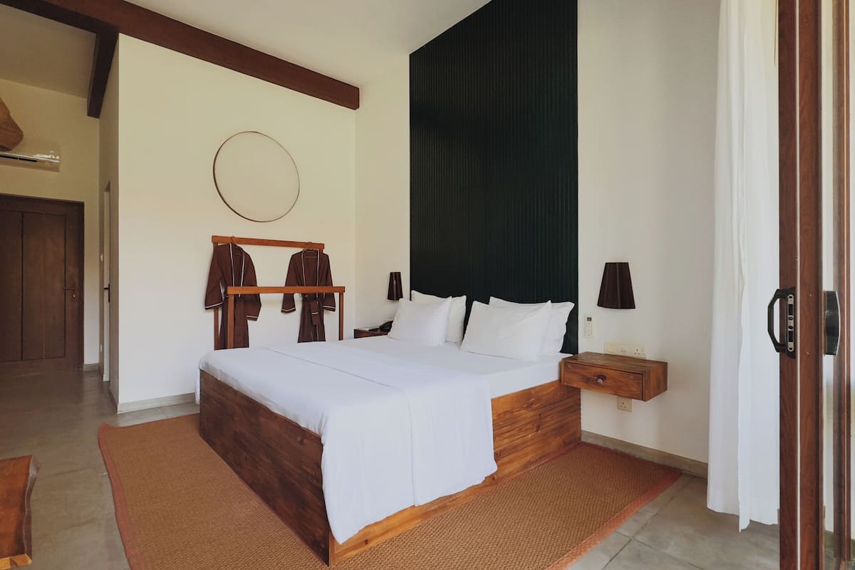 Un dormitorio con cama de madera, mesita de noche, lámpara y lámpara colgante.