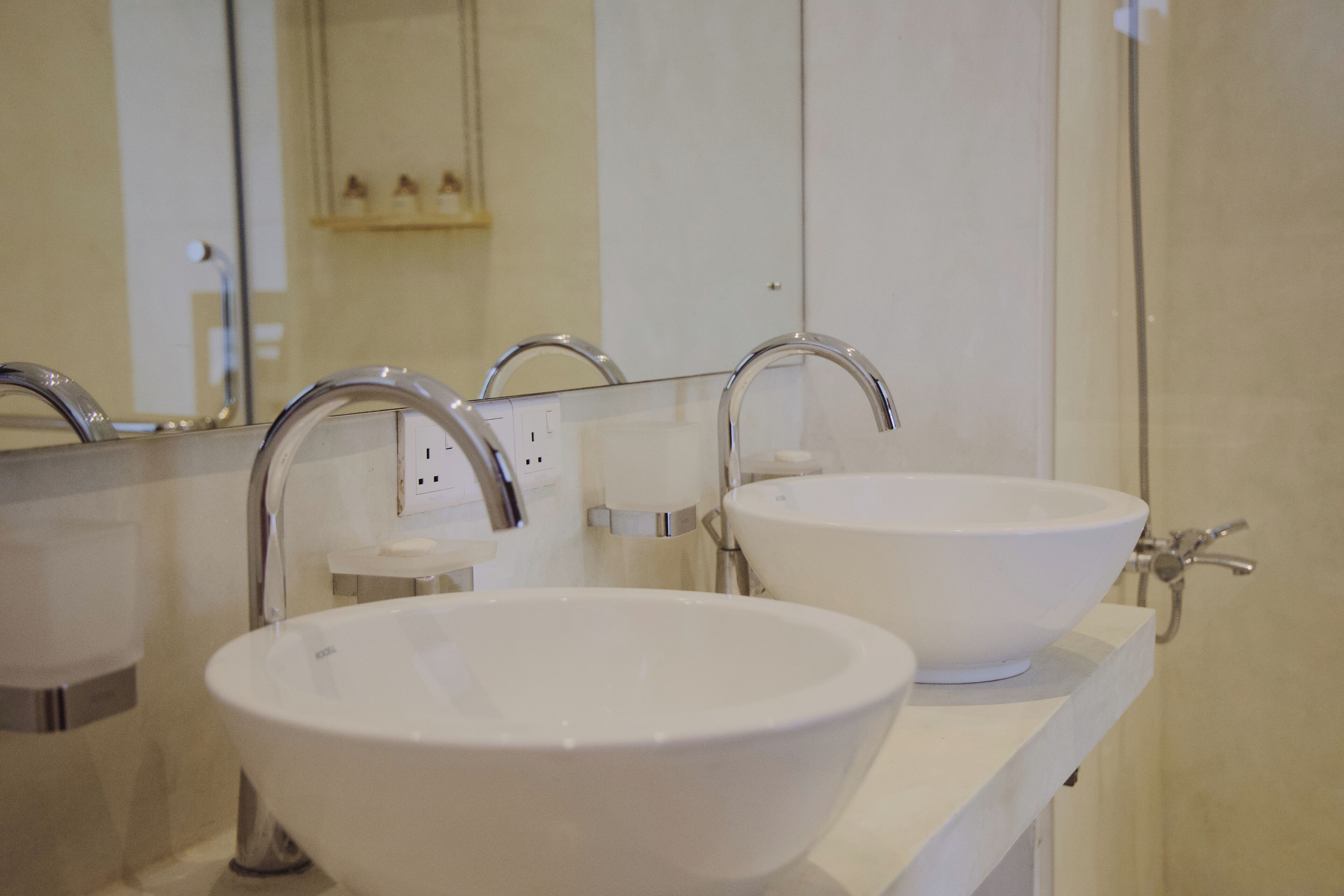 Two white sinks with chrome faucets on a white countertop.