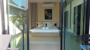 Quarto de hotel moderno com cama, um quadro na parede e vista para o exterior.
