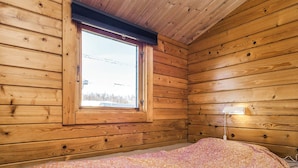 A wooden cabin room with a bed, a window, and a lamp. - 6 Person Holiday Park Home in Gorlev (Gørlev)