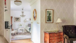 A room with a bed, a chair, a dresser, a lamp, and a painting on the wall. - 3 Person Holiday Park Home in Bastad (Bastad)