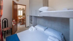 A bedroom with a bunk bed, a desk, and a chair.