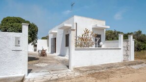 A white building with a tiled entrance and a small patio area.