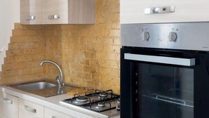 A modern kitchen with a gas stove, oven, and stainless steel sink.