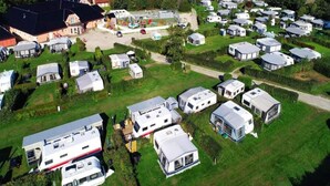 A caravan park with multiple caravans and a building with a red roof. - 6 Person Holiday Park Home in Graested (Graested)