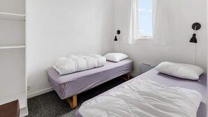 A small, single-bed room with a window, two bedside lamps, and a wardrobe. - 6 Person Holiday Park Home in Vipperod (Vipperod)