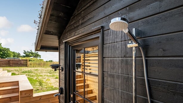 A wooden cabin with a glass door, a showerhead, and a wooden deck. - "Adia" - 650m from the sea by Interhome (Ebeltoft)