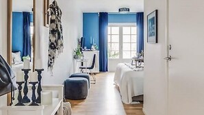 A hotel room with a bed, a desk, a chair, and a window with curtains. - 2 Person Holiday Park Home in Bastad (Bastad)