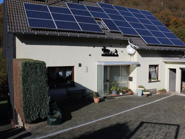 Ein Gebäude mit Solaranlage auf dem Dach, einer Satellitenschüssel und der Zahl 3 an der Wand.