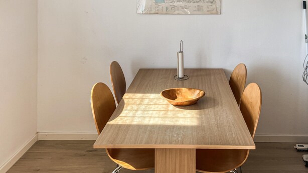 A dining table with a wooden bowl, six chairs, and a map on the wall. - 2 bedroom stunning home in Harboøre (Harboøre)