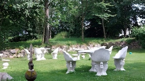 A garden with various white stone sculptures and a bird feeder. - 2 Person Holiday Park Home in Tranekaer (Tranekaer)