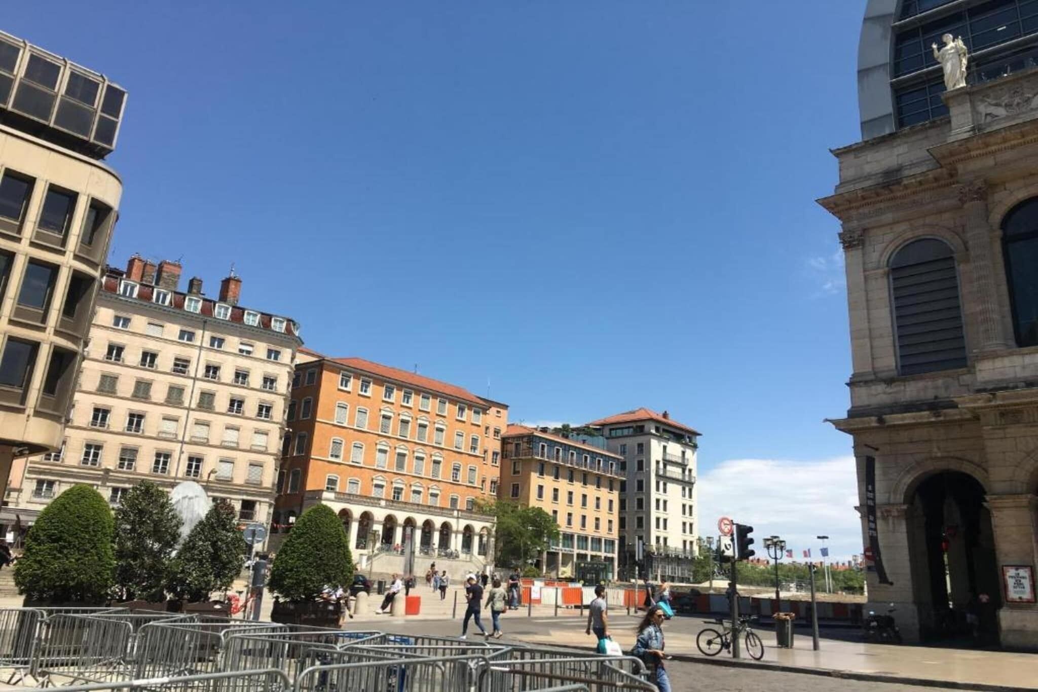 A public square with historic buildings, a statue, and a fountain.