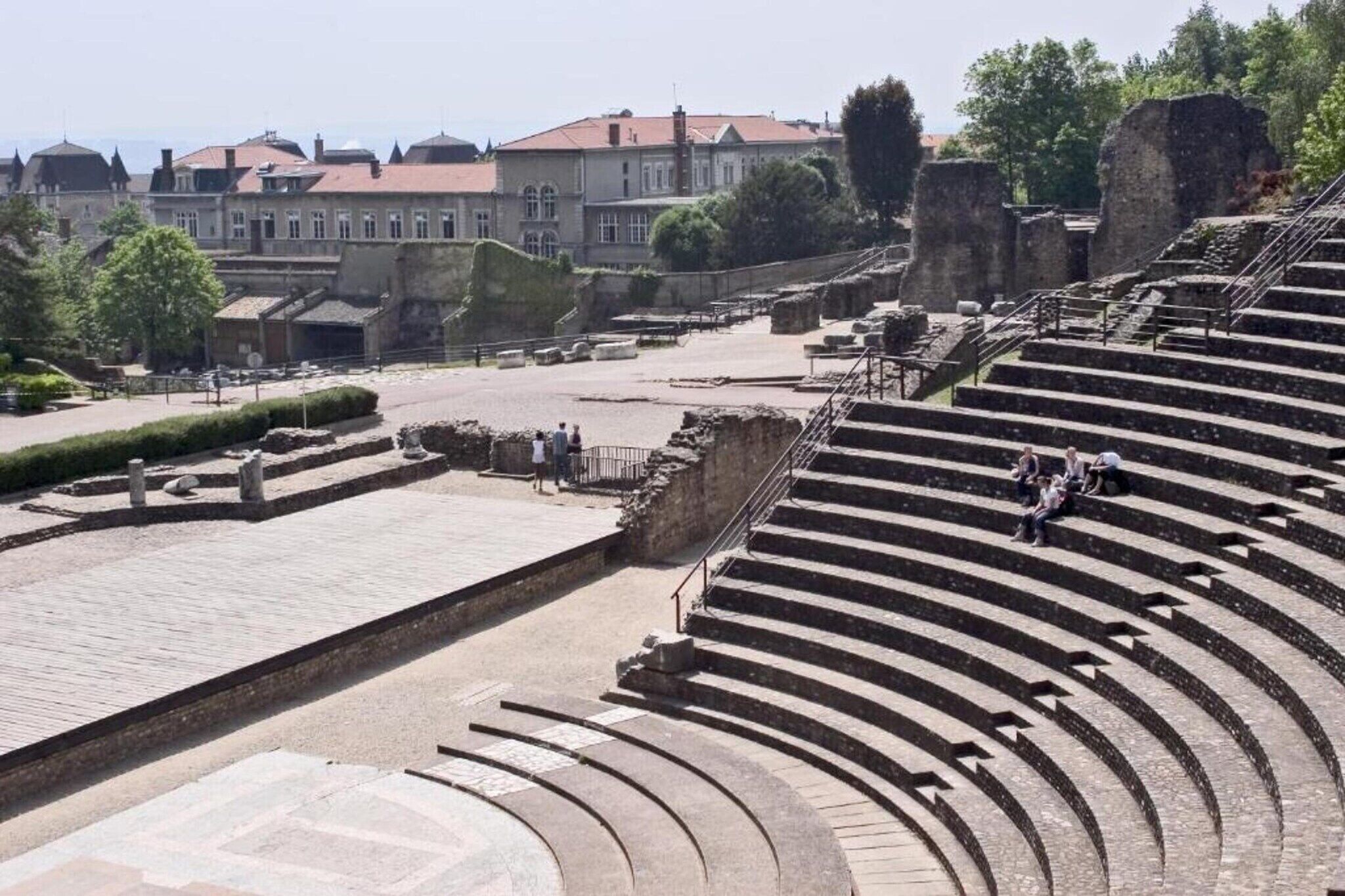 Een eeuwenoud amfitheater met terrasvormige stenen zitplaatsen en ruïnes op de voorgrond.
