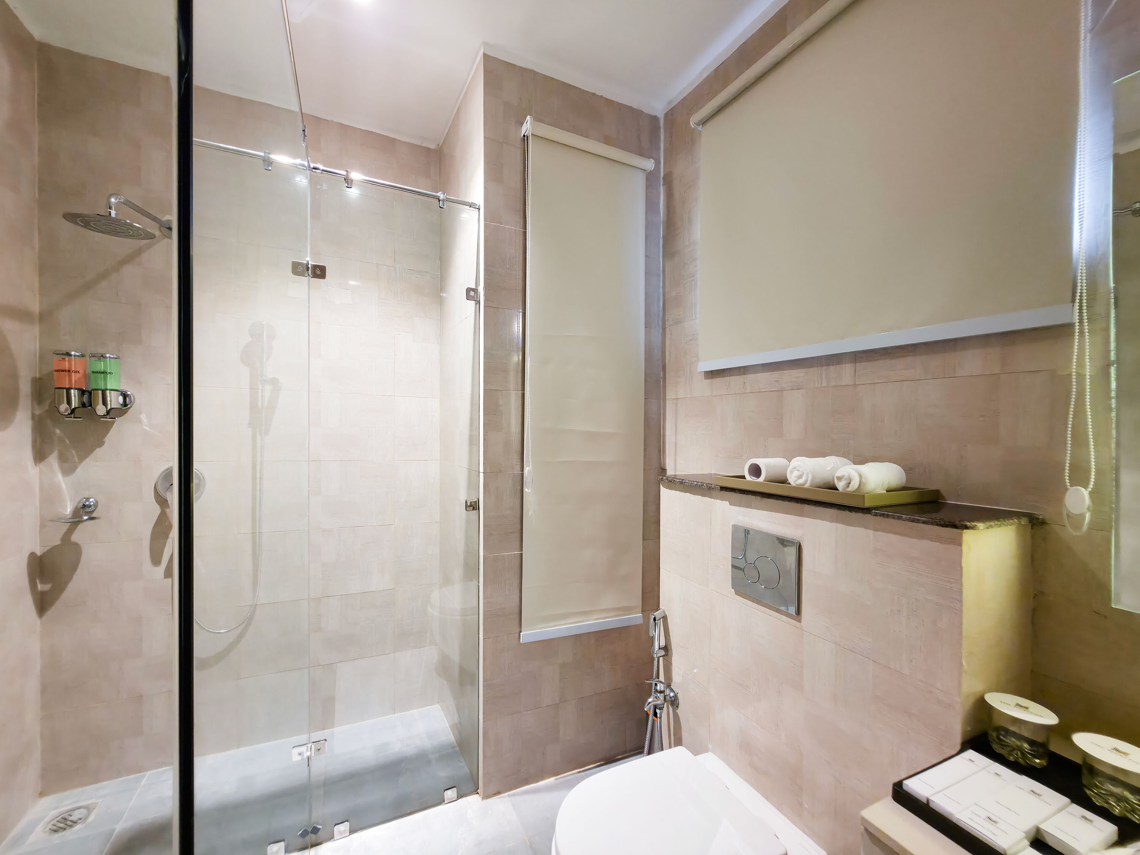 A modern bathroom with a glass-enclosed shower, a vanity with a mirror, and a shelf with toiletries.