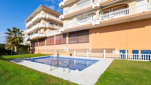 A multi-story residential building with a swimming pool, balconies, and a white fence. - El Morche - Apartment In El Morche. Free Wifi (El Morche, Málaga)