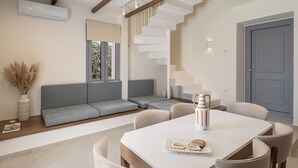 A modern interior with a dining area, a staircase, and a seating area with a view. - Villa Seyian-Charming 3 bedroom villa-Private Pool (CHANIA)