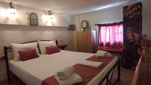 Une chambre à coucher avec un lit, une armoire, un miroir et une fenêtre avec des rideaux.