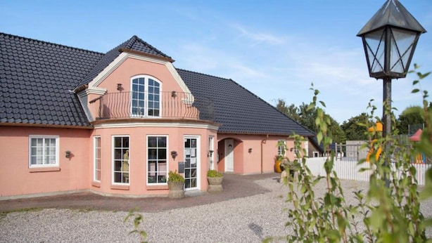 A two-story building with a tiled roof, a balcony, and a gravel driveway. - 2 Person Holiday Park Home in Graested (Graested)