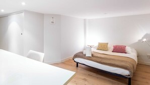Ein modernes Schlafzimmer mit Bett, Nachttisch und einem Sessel.