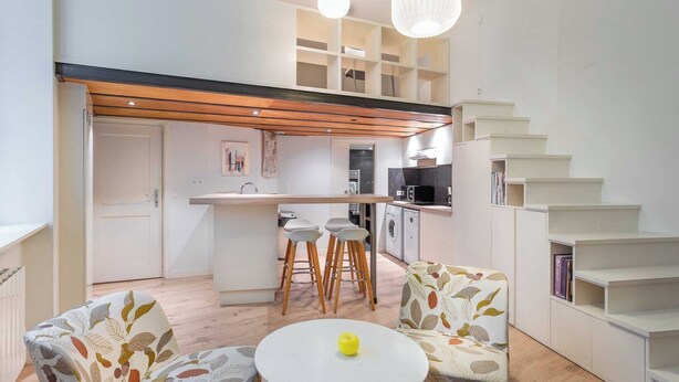 Eine moderne Wohnung mit Küche, Essbereich und einer Treppe.