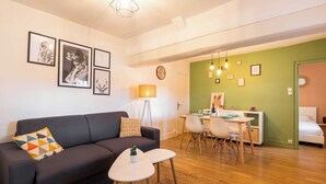 Un soggiorno moderno con divano, tavolino da caffè e zona pranzo.
