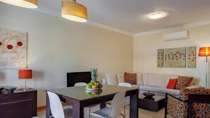 Un salon moderne avec un coin repas, comprenant un ensemble de canapés, une table basse et une table à manger avec des chaises.