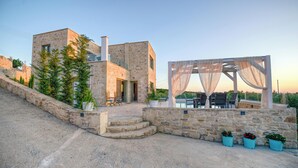 A stone building with a terrace and outdoor seating area. - Koukis Villa With Sea View (Kissamos)