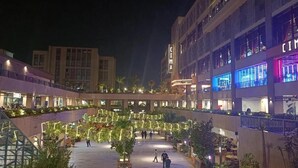A spacious outdoor area with multiple levels, palm trees, and illuminated pathways. - Cozy apartment close to the Giza Pyramids' (El Sheikh Zayed City)