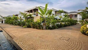 Uma área residencial moderna com ruas pavimentadas, muita vegetação e casas contemporâneas.