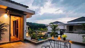 Terraço no telhado com área de refeições, piscina e vista para as casas vizinhas.