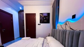 A bedroom with a bed, a door, and a wall with a marble-like design. - Luxury 3BR Ensuite Apartment 24/7 Power Fast WiFi Secure Estate Ikeja Lagos (Ikeja)
