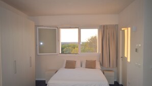 A modern bedroom with a large bed, two bedside tables, a wardrobe, and a window with curtains. - Myrtle studio apartment with sea view terrace, in the dunes 20m from free beach (Monaco Mirante)