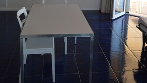 A room with a white table and chairs, a ceiling light fixture, and an air conditioning unit. - Myrtle studio apartment with sea view terrace, in the dunes 20m from free beach (Monaco Mirante)