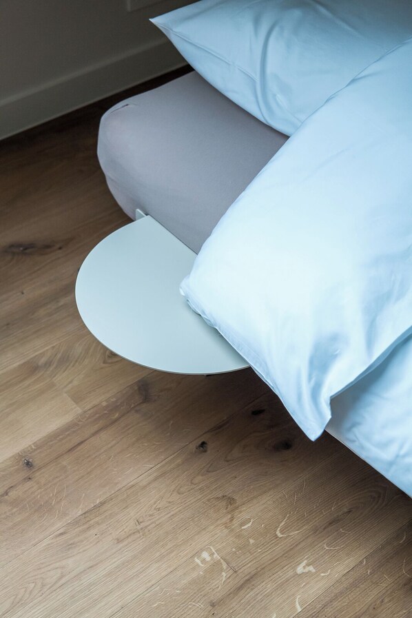 A bed with a round white pillow and a grey mattress. - TAERU - Sporthotel (Erezee)
