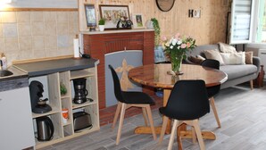 Una cocina moderna con una isla integrada, armarios de madera y un comedor con una mesa redonda y sillas.