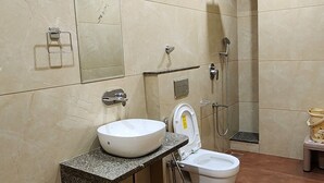 Un baño moderno con tocador de mármol, inodoro y zona de ducha.