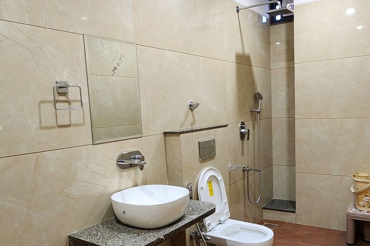 Ein modernes Badezimmer mit Marmor-Waschtisch, Toilette und Duschbereich.