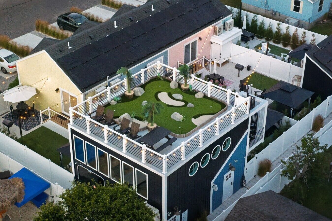 Un bâtiment moderne doté d’un patio sur le toit, d’un espace extérieur aménagé pour s’asseoir et d’un jardin paysager.