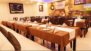 A conference room with multiple tables set for a meeting, equipped with nameplates, notepads, and pens. - Hotel Max INN (Bhagalpur)