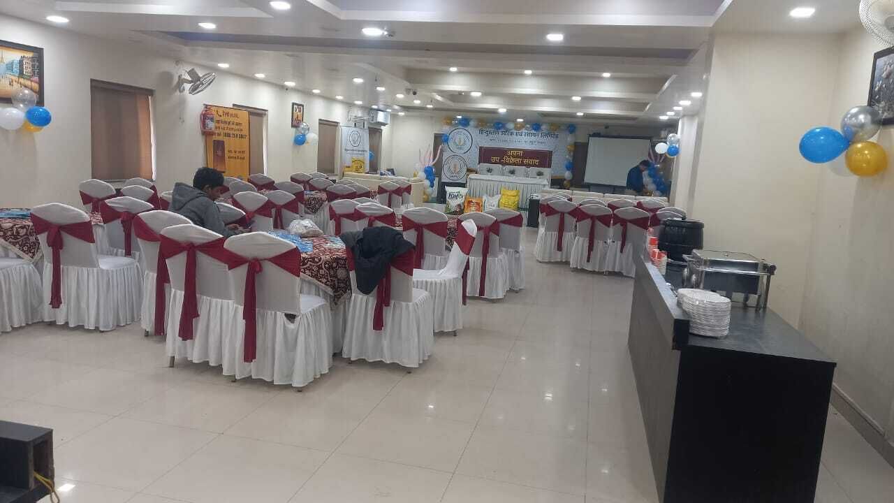 A conference room with rows of tables and chairs, a podium, and a banner on the wall.