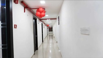 Un pasillo largo y estrecho con paredes blancas y un suelo brillante.